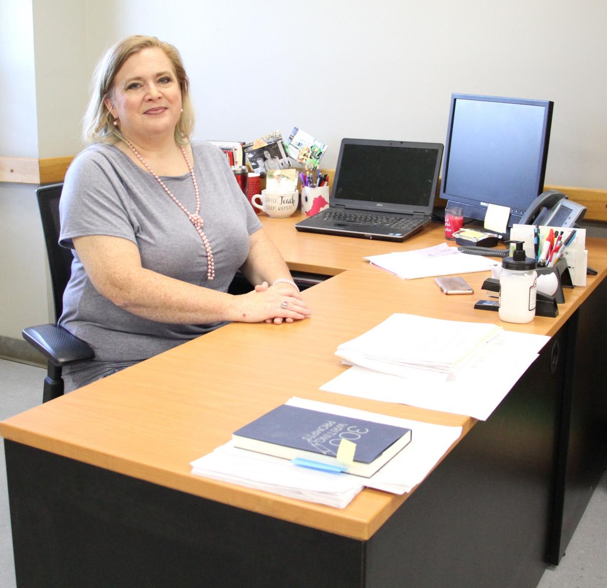 Lori Hutton seated at her desk on the campus of ASUN-Jonesboro